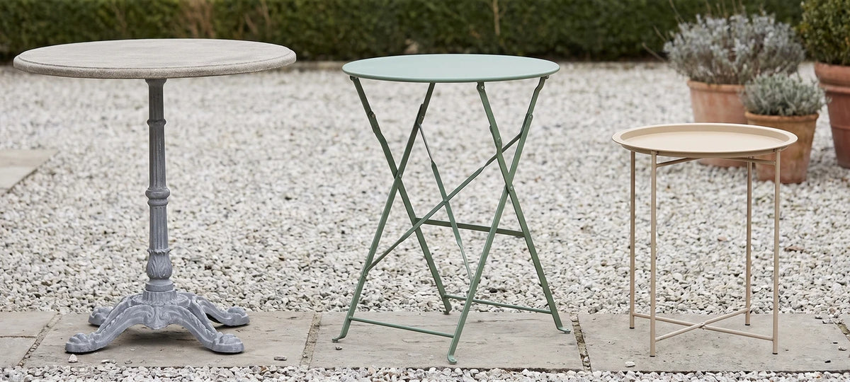 Classical round, green bistro, and stone-top round garden tables on display
